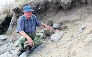  ?? PHOTOS: JENET GELLATLY ?? Beachcombe­r Alan Clark, of Greenhills, points to the pile of rocks which now covers the spot where he came across a cranium (the top part of a human skull) along from Omaui Beach towards the former signal station pilot’s house at the entrance to New River Estuary.