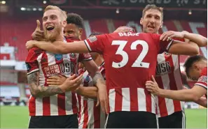  ?? (AFP) ?? Sheffield United’s English-born Scottish striker Oliver McBurnie (left) celebrates with teammates after scoring their third goal against Tottenham Hotspur at Bramall Lane in Sheffield, England, on Thursday.