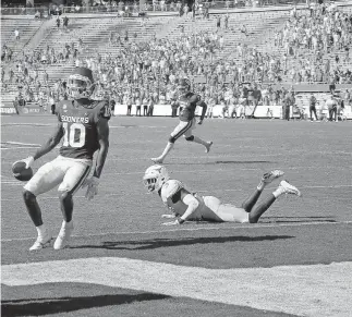  ??  ?? Oklahoma's Theo Wease (10) catches a pass for a 2-point conversion in front of Texas' Jalen Green (3) during the Red River Showdown on Oct. 10 in Dallas. [PHOTOS BY BRYAN TERRY/ THE OKLAHOMAN]