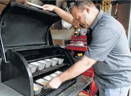  ?? Photos by Marvin Pfeiffer / Staff photograph­er ?? Chuck Blount checks on the sauces in his Traeger grill, stirring them every 20 minutes.