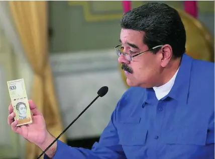  ?? REUTERS ?? Nicolás Maduro con un billete de 500 «bolívares soberanos», la debilitada moneda local