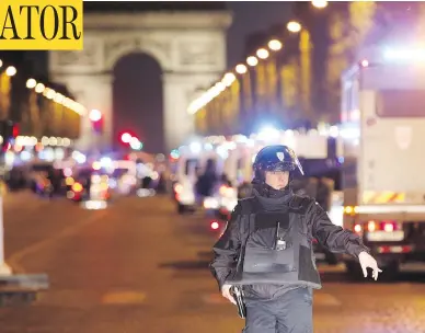  ?? THIBAULT CAMUS / THE ASSOCIATED PRESS ?? A police officer in Paris stands guard after a gunman opened fire on fellow officers with an automatic weapon on the Champs-Elysees, an area popular with tourists, on Thursday, killing one officer and injuring several others.