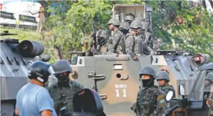  ??  ?? Militares verificam um veículo perto do Salgueiro: cerco contou com blindados, barcos e helicópter­os