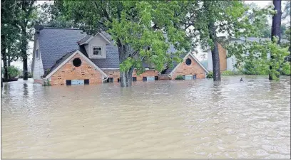  ?? [DAVID J. PHILLIP/THE ASSOCIATED PRESS] ?? Floodwater­s from Hurricane Harvey swamp a home in Spring, Texas, on Monday. An estimated 20 percent of homeowners in Harvey’s path have federal flood insurance. Homeowners insurance typically covers damage from high winds but not floods..