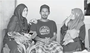  ?? — Gambar Bernama ?? SEDIH: Mohd Fadzil (tengah) yang tidak dapat menahan kesedihan ketika urusan menuntut jenazah tiga anaknya di Unit Forensik Hospital Raja Permaisuri Bainun (HRPB) di Ipoh, semalam.