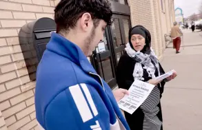  ?? ?? Samra’a Luqman (right) hands out fliers outside of the American Moslem Society Mosque to ask voters not to vote for President Joe Biden after Friday prayers in Dearborn Heights, Michigan.