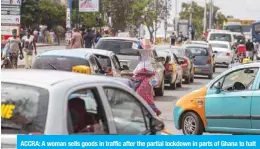  ?? — AFP ?? ACCRA: A woman sells goods in traffic after the partial lockdown in parts of Ghana to halt the spread of the COVID-19 coronaviru­s was lifted in Accra, Ghana on April 20, 2020.