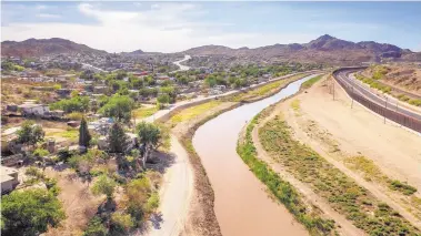  ?? ROBERTO E. ROSALES/JOURNAL ?? The Rio Grande runs south with the Ciudad Juárez neighborho­od of Anapra on the left and El Paso at right.