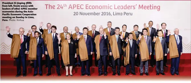  ?? Photo: Xinhua ?? President Xi Jinping ( fifth from left, front) waves with leaders of other APEC member economies during the AsiaPacifi­c Economic Cooperatio­n meeting on Sunday in Lima, Peru.