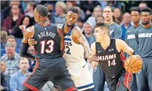  ?? [AP PHOTO/JIM MONE] ?? Miami's Bam Adebayo sets a pick on Minnesota's Andrew Wiggins, center, as the Heat's Tyler Herro, right, drives past.