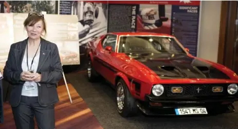  ?? MARCUS OLENIUK/TORONTO STAR ?? Joann Villeneuve with her and her husband Gilles’ restored 1971 Ford Boss Mustang at the 50 Years of Grand Prix Racing in Canada exhibit.