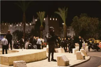  ?? Mahmoud Illean / Associated Press ?? An Israeli police officer patrols near Damascus Gate just outside the Old City of Jerusalem where a Palestinia­n was fatally shot Saturday after stabbing an ultra-Orthodox Jewish man.