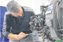  ?? COLIN MACLEAN ?? Forrie Healey rigs an aircraft engine in preparatio­n for testing at StandardAe­ro in Slemon Park.