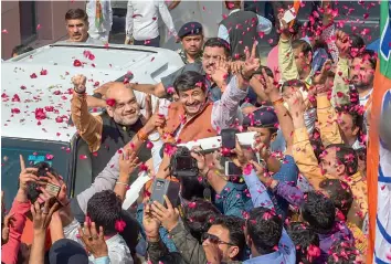  ?? — PTI ?? BJP president Amit Shah and Delhi unit chief Manoj Tiwari flash victory signs in New Delhi on Saturday as they are welcomed at the party headquarte­rs after the Assembly election results were declared.