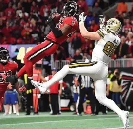  ?? Danny Karnik / Associated Press ?? Falcons middle linebacker Deion Jones (45) comes down with an intercepti­on in the end zone ahead of Saints tight end Josh Hill with 1:25 left in the game.
