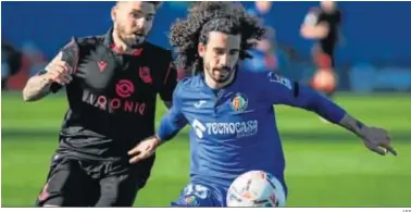  ?? AFP ?? Cucurella protege el balón ante Portu en el duelo celebrado en el Coliseum Alfonso Pérez.