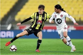  ?? GETTY IMAGES ?? Phoenix’s Max Burgess looks to evade Wanderers’ Raul Llorente during Saturday’s Night’s A-league match in Wellington.