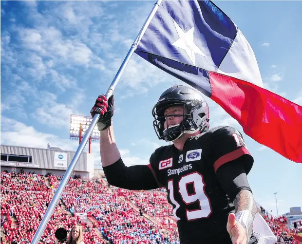  ?? AL CHAREST / POSTMEDIA NEWS ?? Stampeders’ quarterbac­k Bo Levi Mitchell, a native of Katy, Texas, runs out with the Texas flag Monday to support flood victims in his home state.