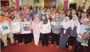  ?? PIC BY AHMAD IRHAM MOHD NOOR ?? Women, Family and Community Developmen­t Minister Datuk Seri Rohani Abdul Karim (centre) with members of the public at the launch of the national-level Mothers Day celebratio­n in Putrajaya yesterday.