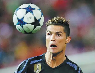  ?? JUAN MEDINA / REUTERS ?? Real Madrid’s Cristiano Ronaldo keeps his eye on the ball during Wednesday’s Champions League semifinal second-leg match against Atletico Madrid at Vicente Calderon Stadium. Atletico won 2-1 but Real advanced 4-2 on aggregate.