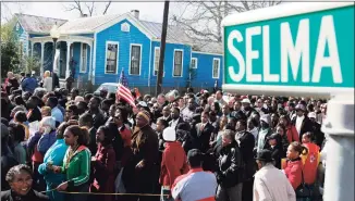  ?? AFP via Getty Images ?? In this file photo, a large crowd marches down the streets of Selma, Ala., while recreating a peaceful voting rights march that was violently repressed by Alabama troopers in 1965.