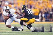  ?? JEFF ROBERSON/ASSOCIATED PRESS ?? Penn State running back Saquon Barkley tries to elude Iowa’s Miles Taylor during last week’s game. The Nittany Lions standout has scored a touchdown in 11 straight games.