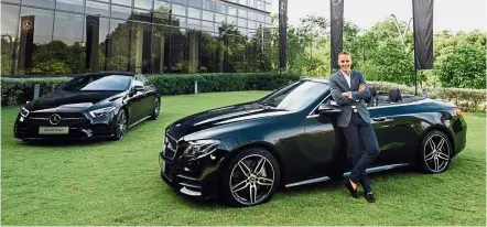  ??  ?? Raine posing with the E 300 Cabriolet (right) and the CLS 450.