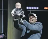  ?? MATT ROURKE THE ASSOCIATED PRESS ?? Utah’s Garett Bolles holds up his son, Kingston, after being selected by the Denver Broncos during the first round of the NFL Draft on Thursday in Philadelph­ia.