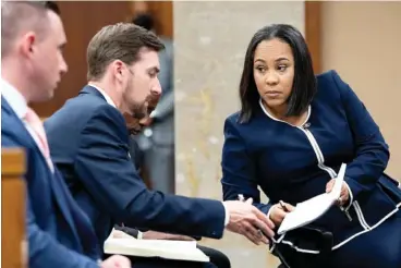  ?? AP PHOTO/BEN GRAY ?? Fulton County District Attorney Fani Willis, right, talks Monday with a member of her team during proceeding­s to seat a special purpose grand jury in Fulton County, Ga., to look into the actions of former President Donald Trump and his supporters who tried to overturn the results of the 2020 election.