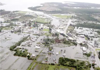  ?? STEVE HELBER/AP ?? Flood waters inundate the town of Engelhard, North Carolina, on Saturday.