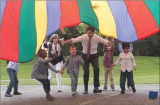  ?? DARRYL DYCK, THE CANADIAN PRESS ?? Prime Minister Justin Trudeau runs under a parachute with children during a visit to the Don Christian Recreation Centre in Surrey, B.C., on Friday. Trudeau will meet with the Pope May 29.