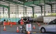  ?? CHRISTINAM­ATACOTTA/ FOR THE AJC ?? Kyle Potts, of the 170th Military Police Battalion, directs cars at the Cobb County COVID- 19 testing site in Marietta, which spent the entirety of its $ 3.1million in aid on fire department salaries.