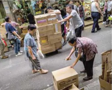  ?? | THE NEW YORK TIMES ?? Una mujer rompe una caja de cartón para reciclar en Hong Kong.