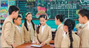  ?? PHOTOS PROVIDED TO CHINA DAILY ?? Top: A scene from the film Little CannedMen featuring two fictional characters as tall as matchstick­s in the pocket of a child’s suit. Above: Lu Xixi (center), a protagonis­t, feels upset in the classroom. Left: Lu’s father tries to comfort her. Below left: A poster of the film.