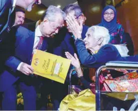  ?? ASHRAF SHAMSUL/ THE SUN ?? Muhyiddin presenting the citizenshi­p certificat­e to 103year-old S. Thanapakki­on at the event yesterday.