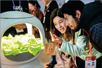  ?? XIAO DA / CHINA DAILY ?? Overseas exhibitors examine a soil-less vegetable cultivatio­n device at the 29th East China Fair in Shanghai earlier this month.