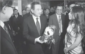  ?? FENG YONGBIN / CHINA DAILY ?? Foreign Minister Wang Yi receives a toy panda as a gift from Sichuan provincial officials at an event held by the ministry in Beijing on Tuesday to promote the province to the world.