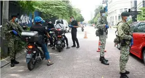  ?? — AZHAR MAHFOF/ The Star ?? Hard at work: Police and army personnel checking motorists at a road block in Jalan Imbi, Kuala Lumpur.