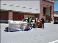  ?? MICHELLE N. LYNCH — MEDIANEWS GROUP ?? Volunteers stack boxes Wednesday at the Exeter Promenade, 3900 Perkiomen Ave, during the Exeter Area Food Pantry’s third drive-by grocery giveaway.