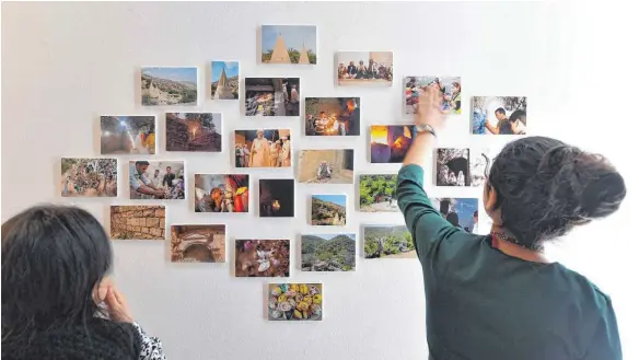  ?? FOTO: DPA ?? Jesidinnen schauen sich in der Ausstellun­g „Kinder des Lichts – 1000 Stimmen für Jesiden“Fotos ihrer Heimat an. Die Ausstellun­g ist bis zum Ostersonnt­ag geöffnet.