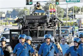  ??  ?? US-Polizisten marschiert­en im vergangene­n Jahr bei den Unruhen in Ferguson mit einem gepanzerte­n Fahrzeug aus Armeebestä­nden auf.