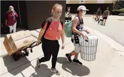  ?? STEPHEN M. DOWELL/ORLANDO SENTINEL ?? UCF student Amanda Craig, middle, with her boyfriend Paul Copeland, right, and her mother Joyce Craig, left, walk on the UCF campus Saturday.