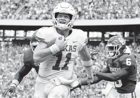  ?? Ronald Martinez / Getty Images ?? Seeing the end zone ahead brings a smile to Sam Ehlinger’s face Saturday. The UT quarterbac­k ran for three touchdowns and passed for two more against Oklahoma.