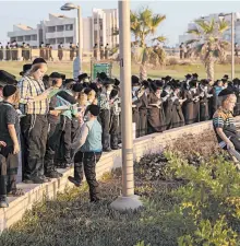  ?? ARIEL SCHALIT/AP ?? Ultra-Orthodox Jews pray on a hill overlookin­g the Mediterran­ean Sea on Thursday in Netanya, Israel. New restrictio­ns to counter the coronaviru­s will affect religious activities.