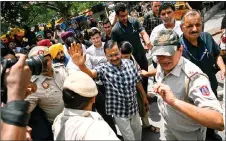  ?? — AFP photo ?? Arvind Kejriwal (centre) waves to supporters during a visit at a Hindu temple in New Delhi, a day after being released on bail by India’s top court to campaign in the ongoing national election.