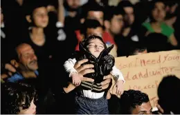  ??  ?? Plea for help A child is held aloft as Syrian migrants gather at Turkey’s border with Greece