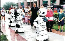  ?? YAN TONG / FOR CHINA DAILY ?? Robots promoting a community’s consumptio­n festival in Beijing attract residents’ attention.