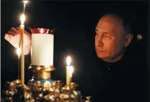  ?? MIKHAIL METZEL VIA AP ?? Russian President Vladimir Putin lights a candle on Sunday in memory of the victims of an attack on the Crocus City Hall concert venue, as Russia observed a day of national mourning.