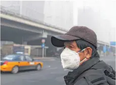  ?? FOTO: AFP ?? Ein Mann wartet im Smog in Peking auf einen Bus.