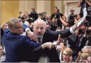  ?? / AP - Antti Aimo-Koivisto ?? Security removes an apparent protester before a joint press conference between U.S. President Donald Trump and Russia President Vladimir Putin in the Presidenti­al Palace in Helsinki, Finland, on Monday.